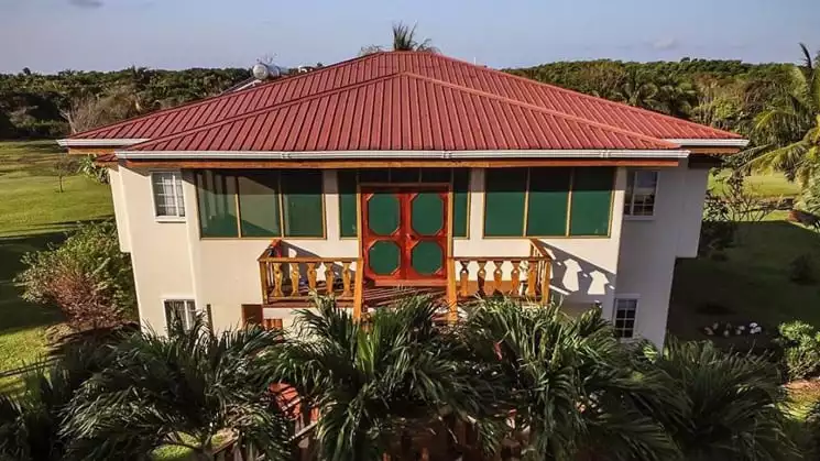 The Garden Villa at Turneffe Flats with red roof and small porch on second floor.