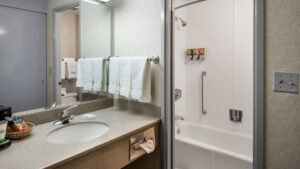A bathroom inside a guest room with sink, vanity, and hot shower at the Westmark Anchorage, a downtown hotel that was recently renovated