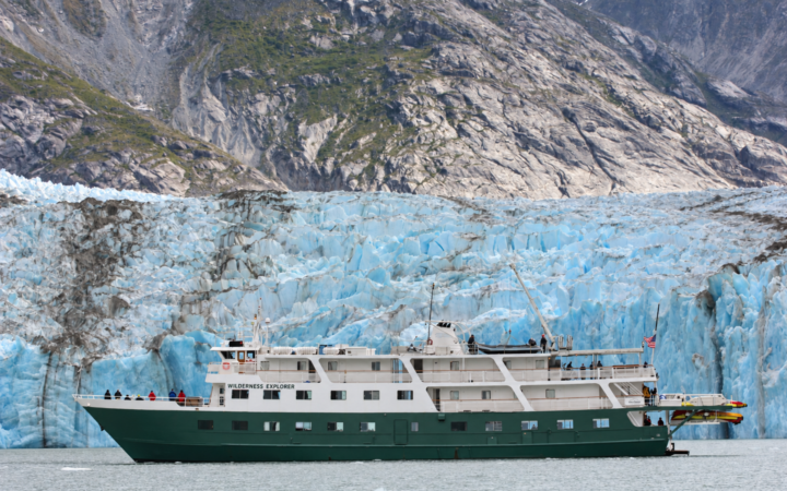 Wilderness Explorer expedition ship sailing with a dramatic backdrop of Dawes Glacier.