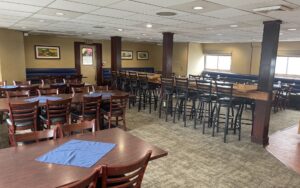 Dining room with tables, chairs and large windows aboard Wilderness Explorer.