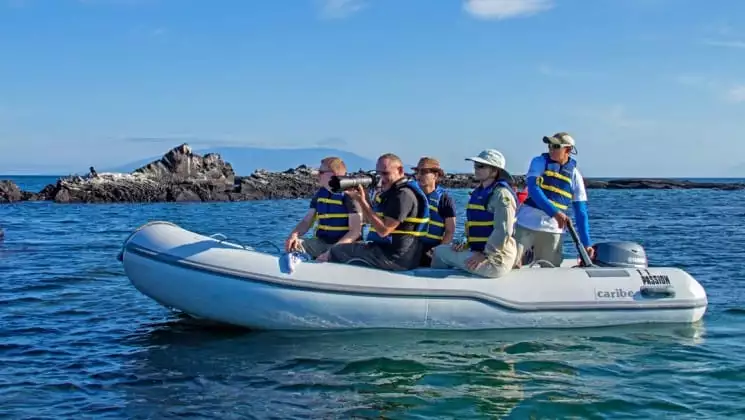 a dinghy full of passengers from the passion luxury cruise heads toward the Galapagos for a day's excursion