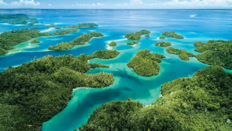looking down the many of islands of indonesia with turquoise and aqua colored ocean in between