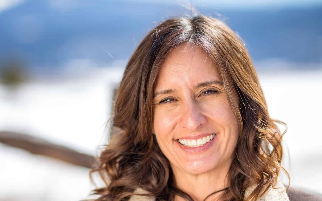 adventuresmith explorations chief financial officer lisa exley-smith smiling with bright snow behind her