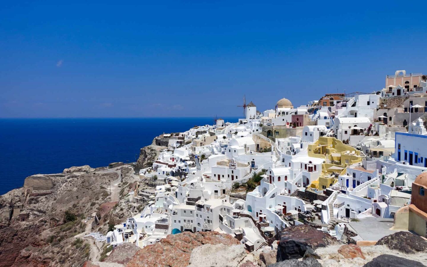 A Greece city view in the Mediterranean with white buildings and a deep blue sea.