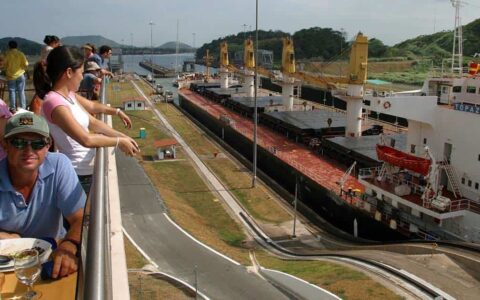 adventure travelers relax and watch small ships travel through the miraflores locks during the Panama Discovery land tour