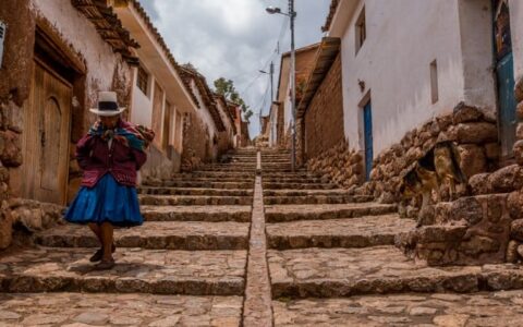 older woman descending cobblestone steps on peru highlights trip