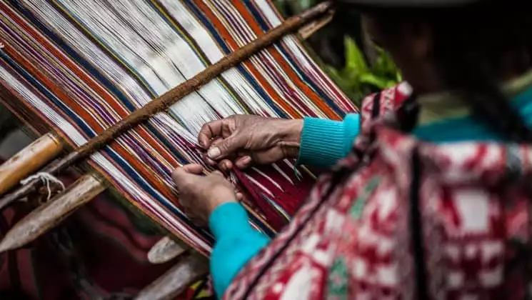 closeup of hands of woman weaving on sacred valley & lares adventure to machu picchu land tour