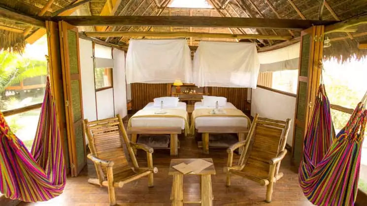 Inkaterra Superior Rio room with twin beds, chairs, windows and mosquito nets.
