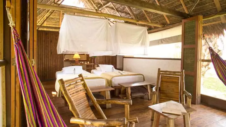 Inkaterra Superior room with beds, chairs and mosquito nets.
