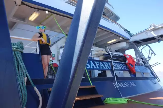 Baja small ship crew member posing on the back of the boat with extra large green sunglasses.