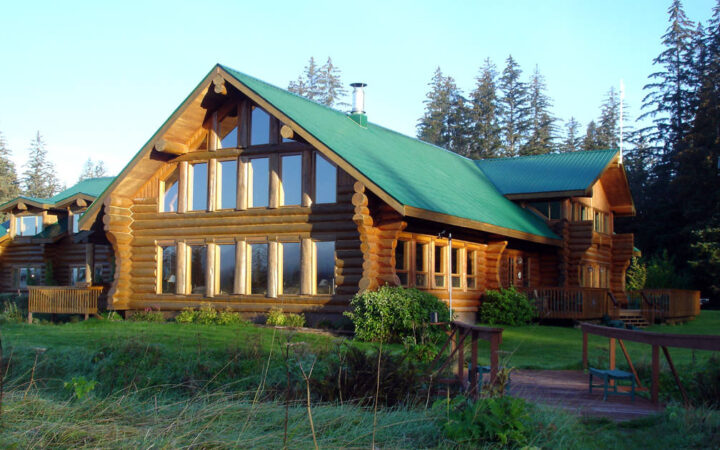 Large windows at the Bear Track Inn face large growth forest, open meadows, and views of Icy Strait in Alaska