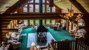 The lobby, with a wood fire place, chandeliers, and comfortable couches, at the Bear Track Inn, near Glacier Bay, Alaska