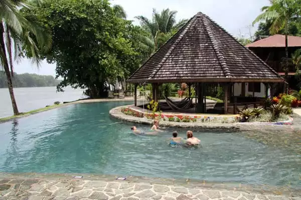 Young traveler children playing in the pool of a Costa Rican lodge next to the ocean.