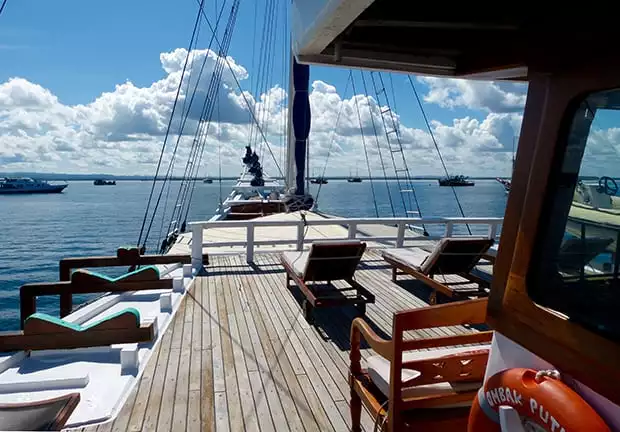 Bow of the Ombak Putih with lounge chairs on deck as it sails through Indonesia. 