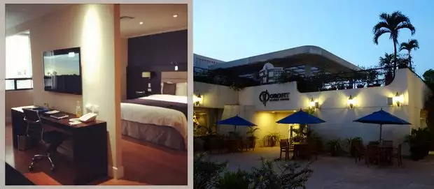 Inside a room at the Oro Verde hotel with desk and bed and outside view of the outdoor patio.