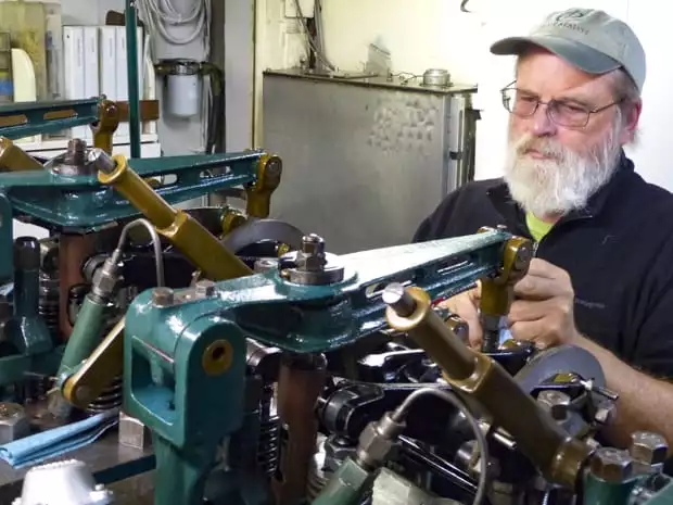 Westward small ship cruise captain works on the boat engine.