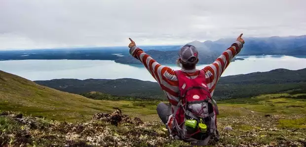 Guest at  Skilak lake backcountry lodge at viewpoint overlooking waterway in Alaska. 