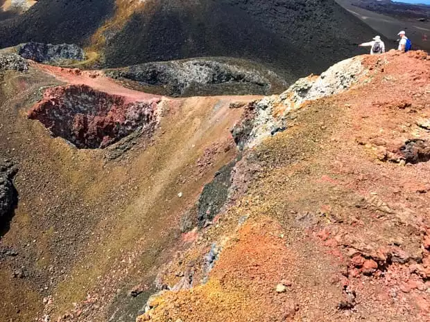 2 hikers walking a trail along a ridge top in the Galapagos.