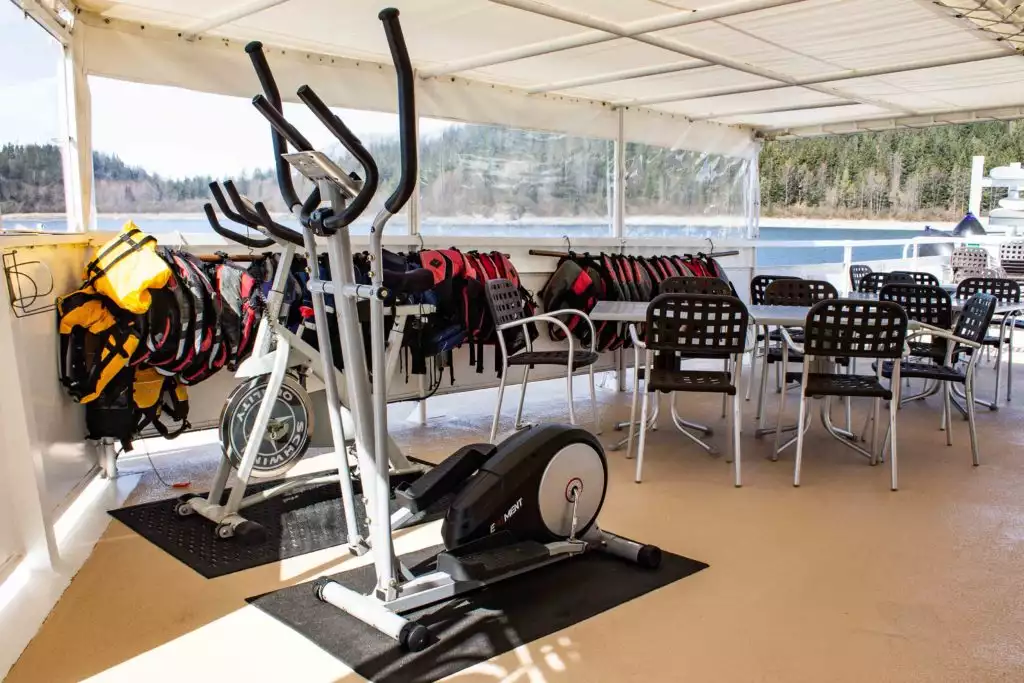 the gym aboard Wilderness Adventurer a semi outdoor area with a white cover over the deck and clear plastic tarps for wrap around windows.