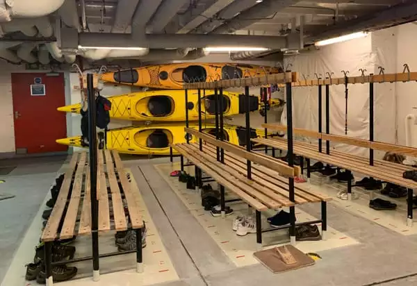 The mudroom with hooks, benches and kayaks aboard Expedition