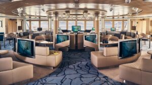 Rendering of lounge with couches, chairs, tables, bar and large windows aboard National Geographic Resolution polar expedition ship