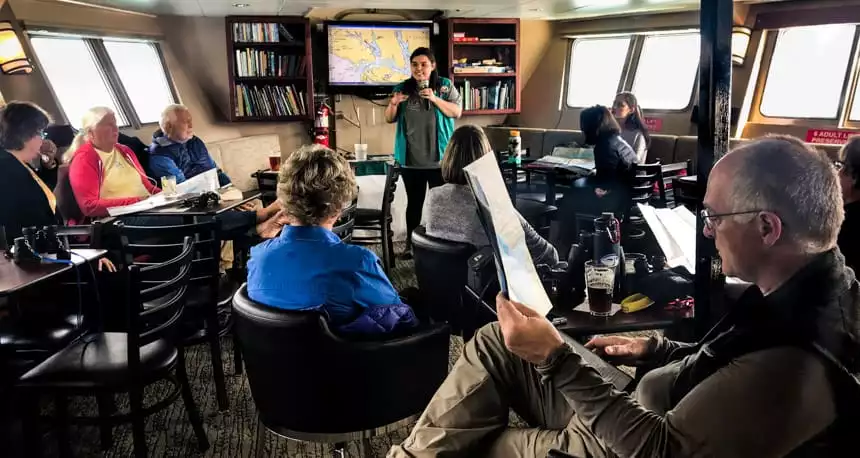 alaska travelers sit and listen to lecture given inside admiralty dream small ship 