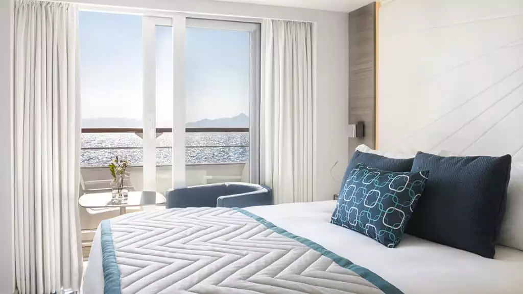 Grand Deluxe Suite with king bed aboard Le Lyrial. Photo by: Francois Lefebvre/Ponant