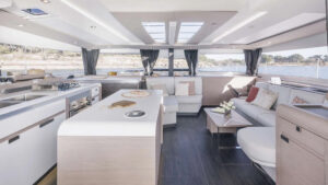 Interior of Belize small ship catamaran with a modern light design featuring a kitchen, sitting area and large windows.