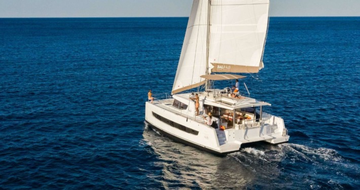 Belize charter yacht Magnificent, a 48-foot while catamaran, cruises in calm water with both sails fully open.