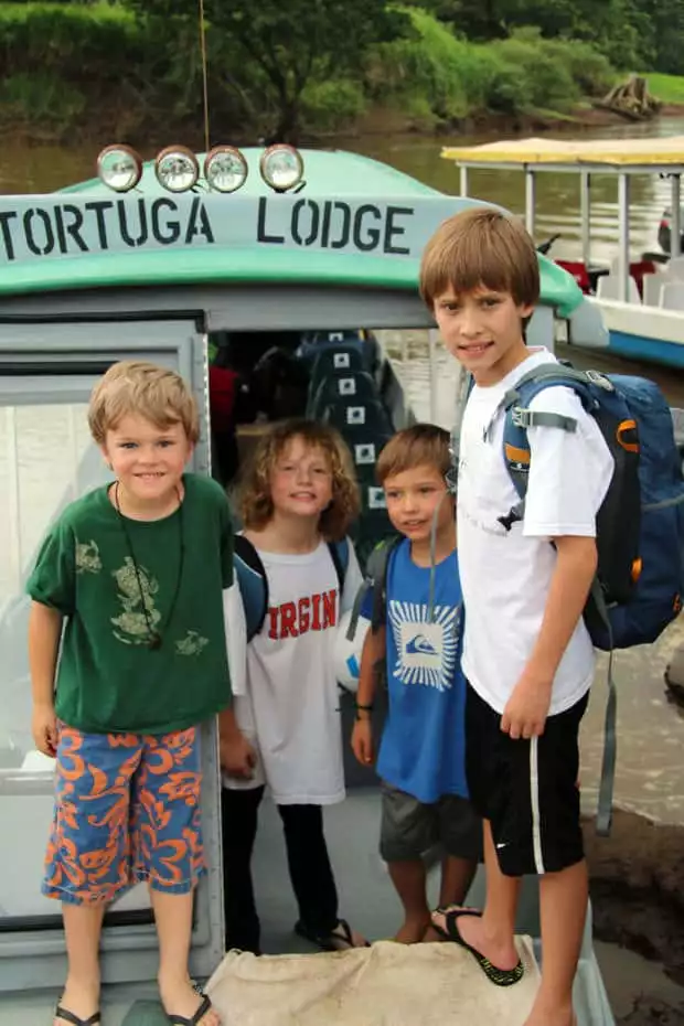 Group of young travelers embarking on a river boat in Costa Rica.
