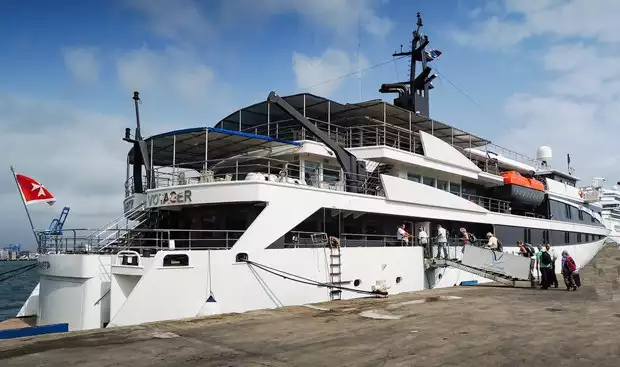 Small ship cruise Variety Voyager docked with travelers embarking on to the boat.