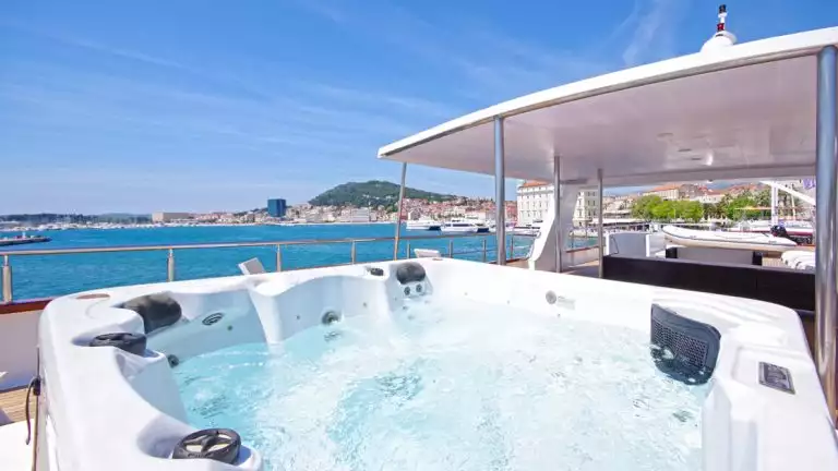Close-up view of the water in the Aurora yacht's hot tub with a Croatia town seen behind it
