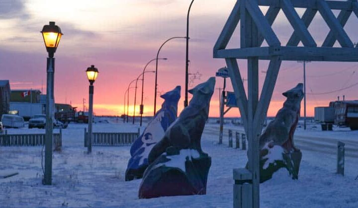 Wolf statues at sunset outside Churchill Hotels on the snow-covered streets of the Arctic town of Churchill