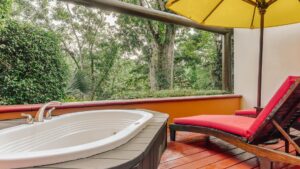 Private outdoor Jacuzzi with shaded lounging area and rainforest views at the Lodge at Chaa Creek in Belize.