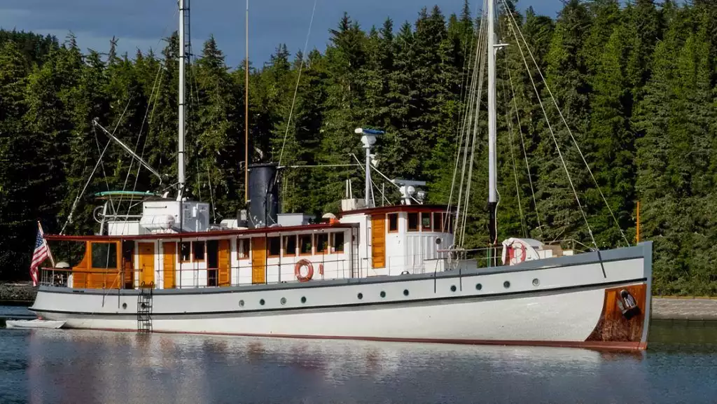 Westward exterior picture of starboard side with green pine tree forest in background