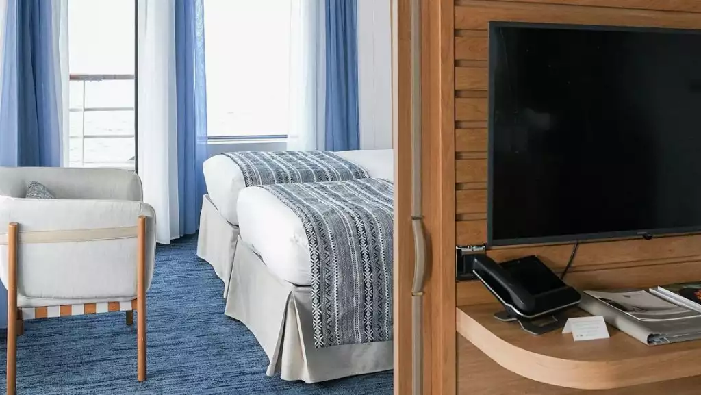 Grand Deluxe Suite bedroom with twin beds aboard Le Laperouse. Photo by: Ponant