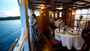 Female looking out open deck in salon dining room aboard Tucano.