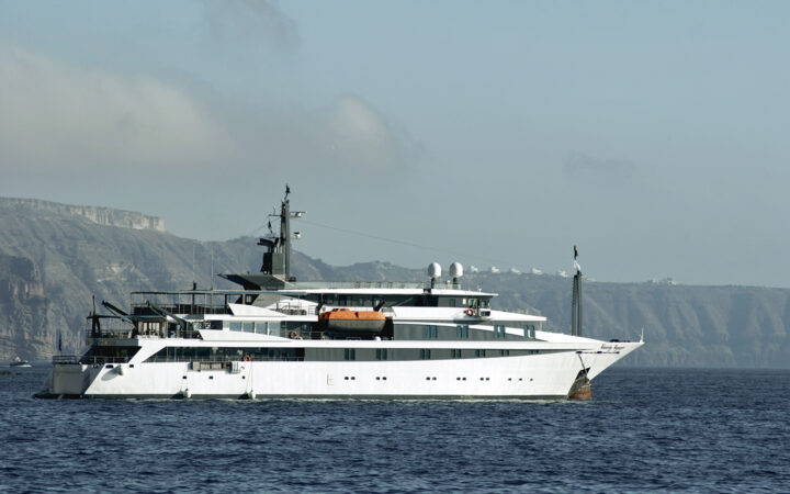 The white Variety Voyager Greece yacht seen sailing from its starboard side by the cliffs of Santorini
