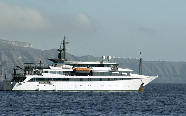 The white Variety Voyager Greece yacht seen sailing from its starboard side by the cliffs of Santorini