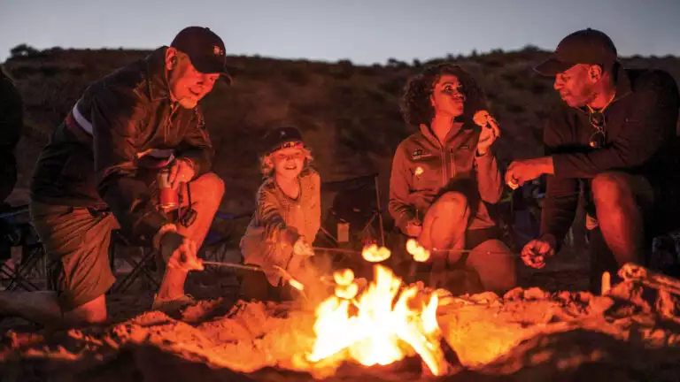 Guests are enjoying s'mores around a campfire in Baja California, Mexico.