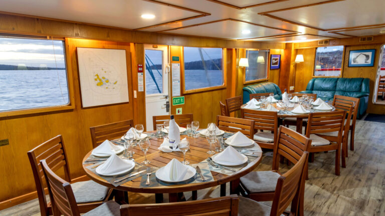 Set tables in dining room by lounge aboard Cachalote Explorer.
