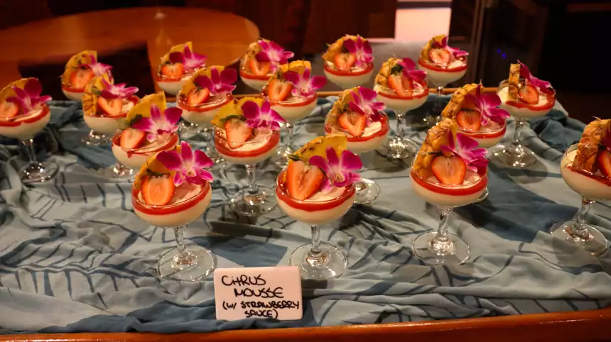 Beautiful dessert in wine glasses with strawberries, pineapple and flowers