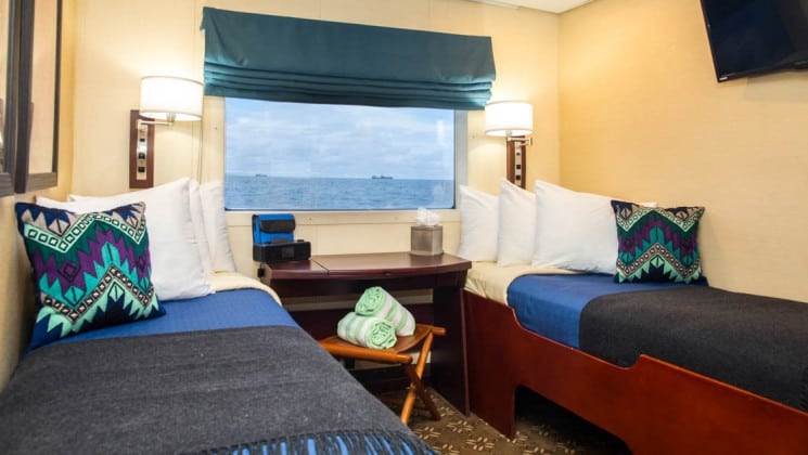 Safari Voyager Panama small ship Navigator cabin with twin beds, a desk and large window