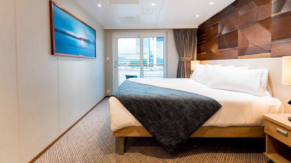 Bridge Deck Stateroom aboard Coral Adventurer with veranda and large bed.