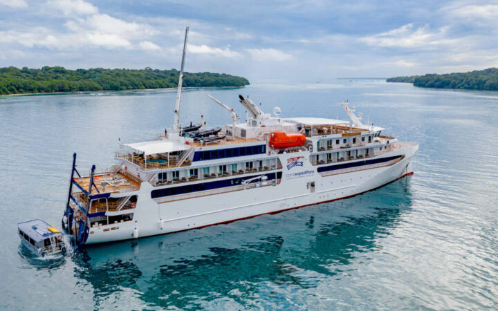Aerial view of the starboard side of the Coral Adventurer with the xplorer tender at the stern.