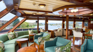 Lord of the Glens lounge area with bar, chairs, couch, tables and large picture windows throughout.
