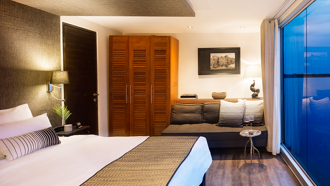 aria amazon bedroom at night that has a full size bed with white sheets.