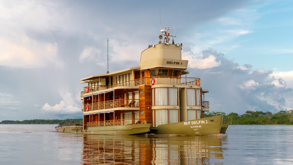 Exterior shot of Small river boat Delfin cruising through the amazon on a cloudy day
