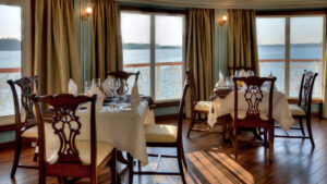 Jahan dining room with floor to ceiling windows, tables and chairs set up for a meal.