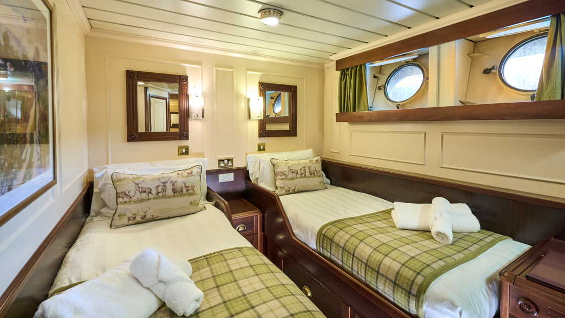 Cabin, Category 1, 111 square feet. Cabin features two portholes and a double bed or two single beds on the Watt deck aboard the ship Lord of the Glens.
